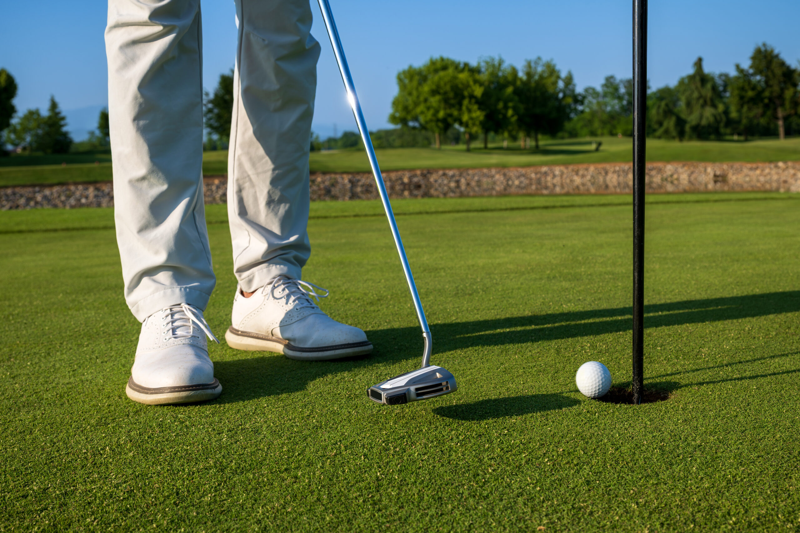 Golfer performing a putt shot with Kolf Maison's superior golf gear